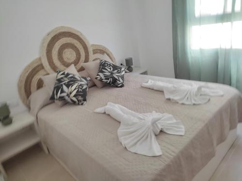 a bed with white sheets and pillows on it at Apartament La Morra in Sant Carles de la Ràpita