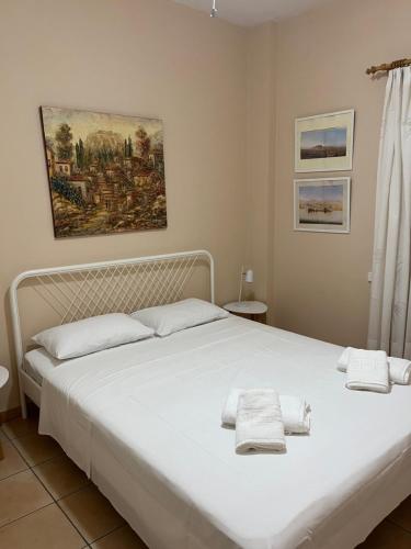 a bedroom with a white bed with towels on it at Theoni's village apartment I in Kalamata