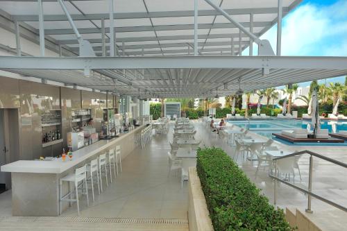 a resort with a pool and tables and chairs at Nestor Hotel in Ayia Napa
