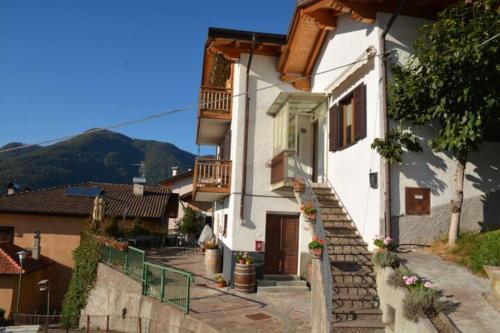 a white house with stairs leading up to it at Apt. BELLA VISTA nel Cuore della Valle di Cembra. in Segonzano