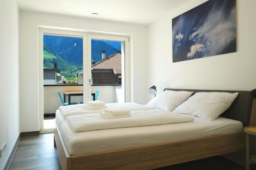 um quarto com uma cama grande e uma janela grande em Apartment Oleander em Naturno