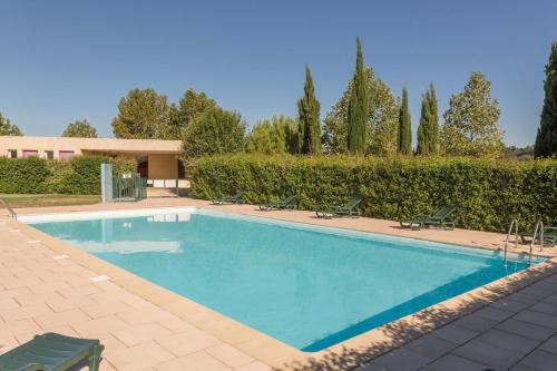 - une piscine avec 2 chaises et une maison dans l'établissement Appart'City Classic Aix en Provence - Fuveau, à Fuveau