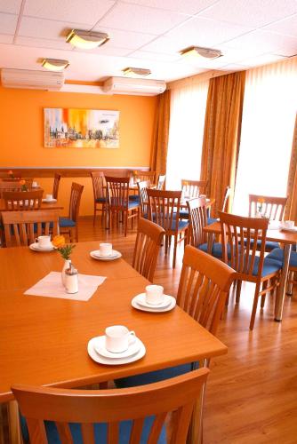 a dining room with wooden tables and chairs at Hotel Evido Salzburg City Center in Salzburg