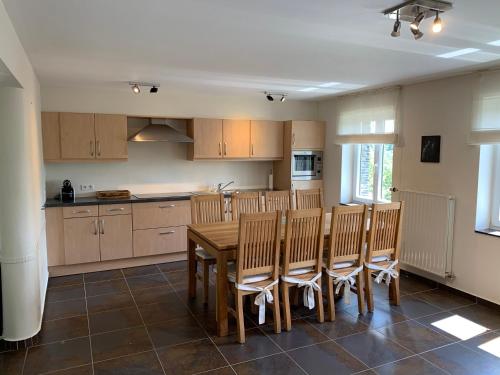 a kitchen with a wooden table and chairs at Castorama in Rochehaut