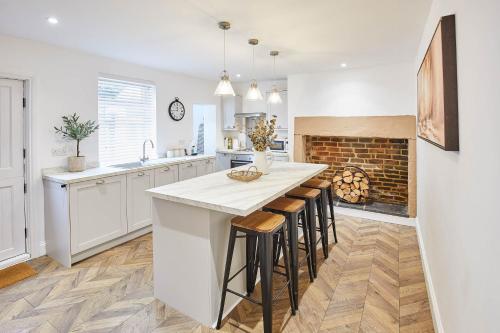 a kitchen with white cabinets and a fireplace at Host & Stay - Tally House in West Rainton