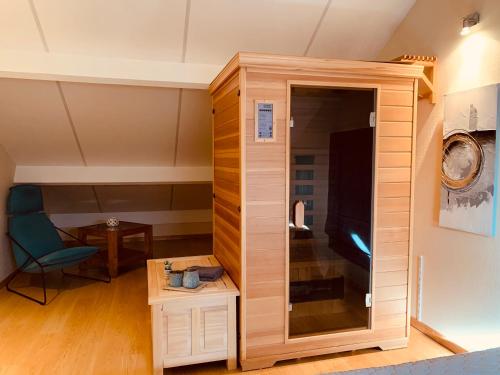 een kamer met een grote houten kast en een stoel bij Castorama in Rochehaut