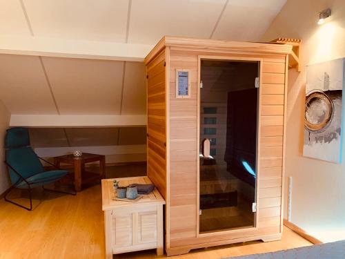a room with a large wooden cabinet and a chair at Castorama in Rochehaut