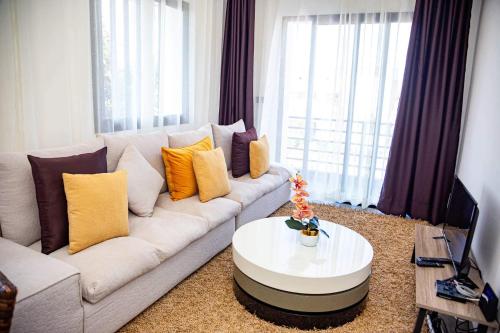 Yvanka Appart'City Antsirabe في أنتسيرابي: غرفة معيشة مع أريكة بيضاء وطاولة قهوة