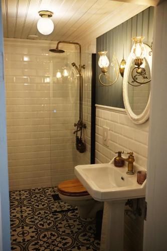 a bathroom with a sink and a toilet and a mirror at Sylte Hotell, Valldal in Valldal