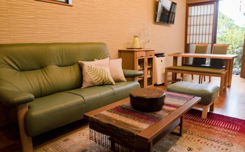 a living room with a green couch and a table at 京 吉乃家 in Kyoto