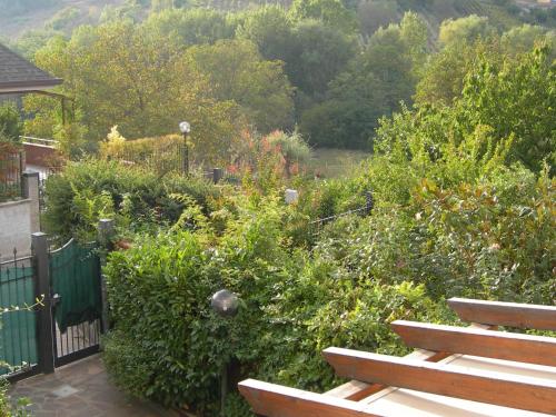 a garden with a wooden bench and bushes at The Flowers' House in Potenza