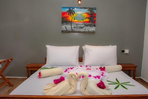 a bed with flip flops and flowers on it at little pompeji boutique hotel - adults only in Jambiani