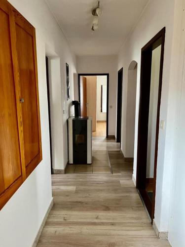 a hallway of an apartment with wooden floors and white walls at Ferienwohnung am Mattsee in Guggenberg