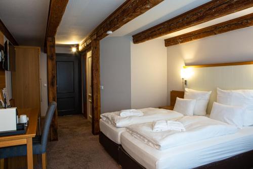 a hotel room with two beds and a desk at Romantik Hotel Aquarium in Friedrichstadt