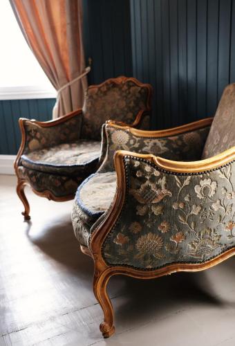 two antique chairs in a room with a curtain at Sylte Hotell, Valldal in Valldal