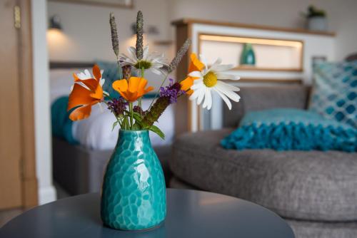 a blue vase with flowers sitting on a table at Bonnie Barns - Adults Only Luxury Lodges with hot tubs in Luss