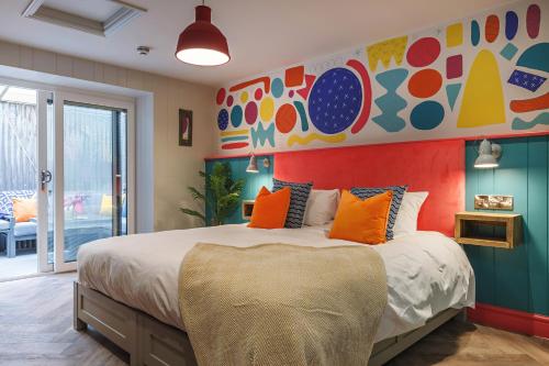 a bedroom with a large bed with a colorful headboard at Ffolkes Arms Hotel in Hillington