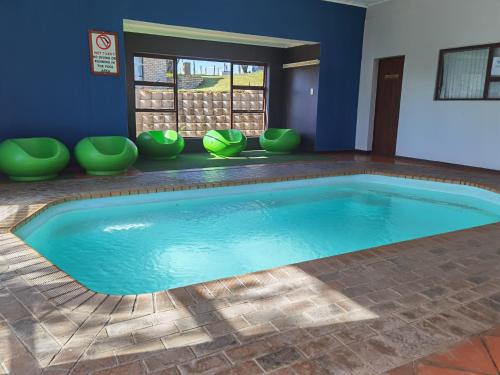 a large pool in a room with green chairs at Eagles Nest in Sedgefield