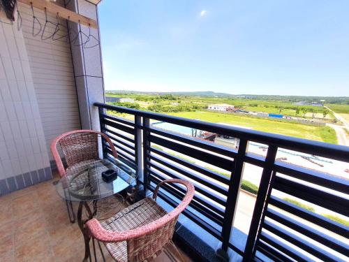 a balcony with a table and chairs and a view at Warm & Cozy Inn in Hengchun
