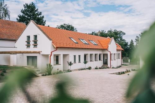 une image d'une maison avec un toit orange dans l'établissement Kardamom Studio Apartman, à Szigliget