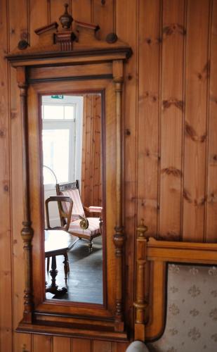 a mirror in a room with a chair and a table at Sylte Hotell, Valldal in Valldal