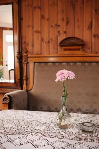 a vase with a pink flower sitting on a table at Sylte Hotell, Valldal in Valldal