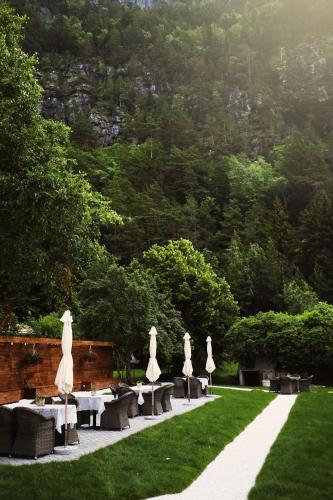a group of white umbrellas and tables in a park at Sylte Hotell, Valldal in Valldal