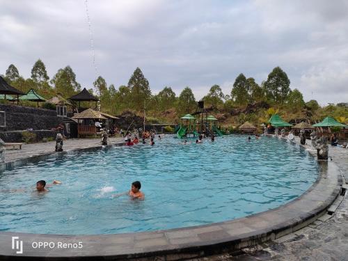 mensen zwemmen in een zwembad in een waterpark bij Batur Water Park Villa in Bangli