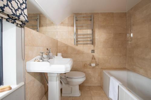 uma casa de banho com um lavatório, um WC e uma banheira em Spindrift, St Ives em St. Ives