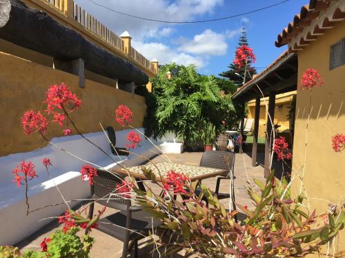 a patio of a house with red flowers at Casa Rural La Gañanía in Los Realejos