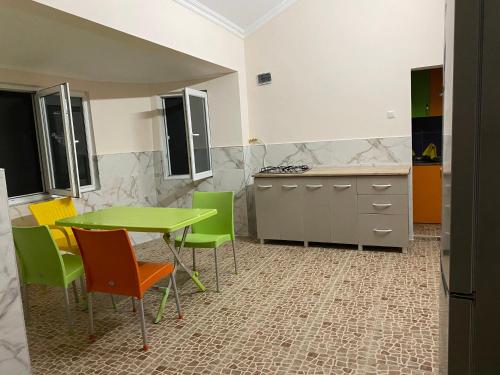 a kitchen with a green table and chairs at Guest House Sophie in Gonio