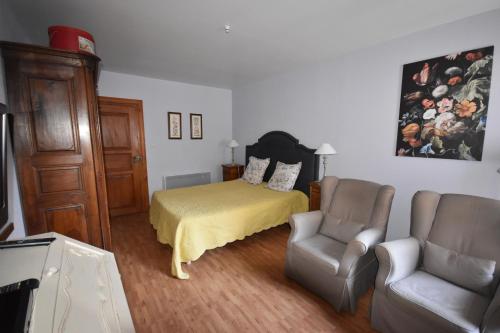 a bedroom with a bed and a couch and a chair at Les Hortensias in Riquewihr