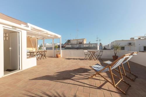 a patio with chairs and tables on a roof at Casa ao Cubo in Olhão