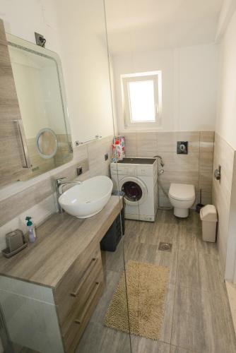a bathroom with a sink and a washing machine at Secluded house with seawater pool in Milna