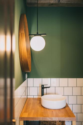 a bathroom with a tub on top of a wooden table at Kardamom Studio Apartman in Szigliget