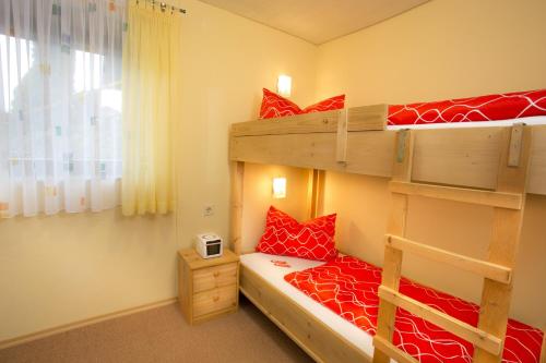 a bedroom with two bunk beds with red pillows at Ferienappartements mit Herz in Bischofsmais