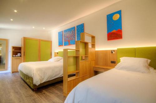 a bedroom with two beds and a book shelf at Hôtel Casale Olmia 