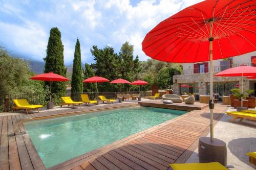 - une piscine avec des parasols rouges et des chaises jaunes dans l'établissement Hôtel Casale Olmia, à Moncale