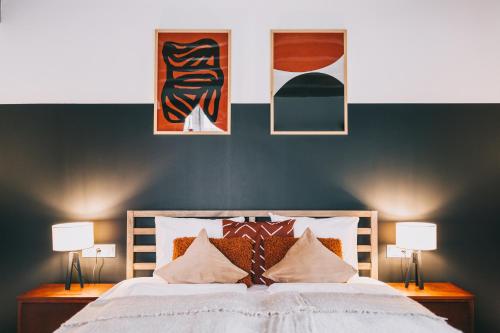 a bedroom with a large bed with two lamps at Kardamom Studio Apartman in Szigliget