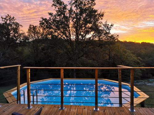 - une piscine sur une terrasse au coucher du soleil dans l'établissement Maison typique périgourdine avec piscine, à Paulin