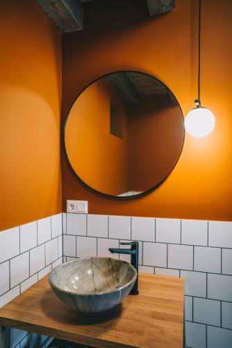 a bowl on a counter in a bathroom with a mirror at Kardamom Studio Apartman in Szigliget