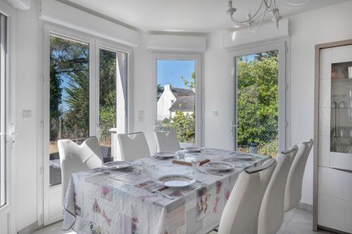 une salle à manger blanche avec une table et des chaises blanches dans l'établissement Maison 6 personnes avec accès privé à la plage !, à Sarzeau