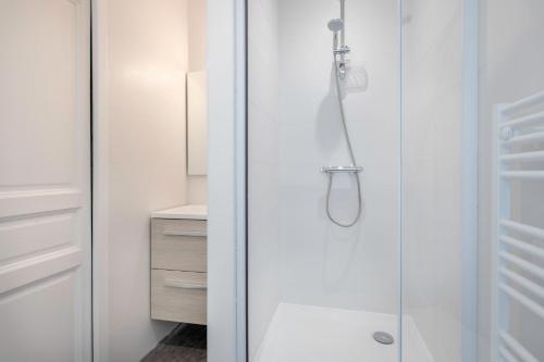 y baño con ducha y puerta de cristal. en Charmant appartement vue mer au coeur du Croisic, en Le Croisic