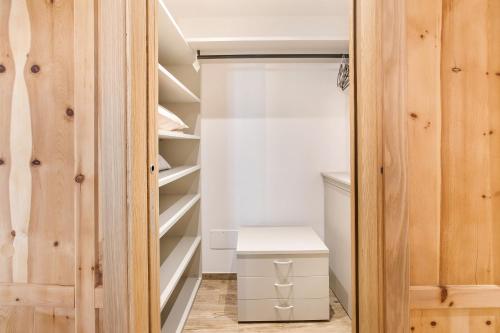 einen begehbaren Kleiderschrank mit Holzschränken und einer weißen Schublade in der Unterkunft Casa Cecilia tra Bormio e Livigno in Valdidentro
