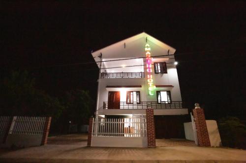 a white house with a lit up sign on it at night at Amazing Hotel, Trương Pháp, Quang Phú, Đồng Hới in Dong Hoi