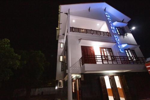 a white building with a blue sign on it at night at Amazing Hotel, Trương Pháp, Quang Phú, Đồng Hới in Dong Hoi