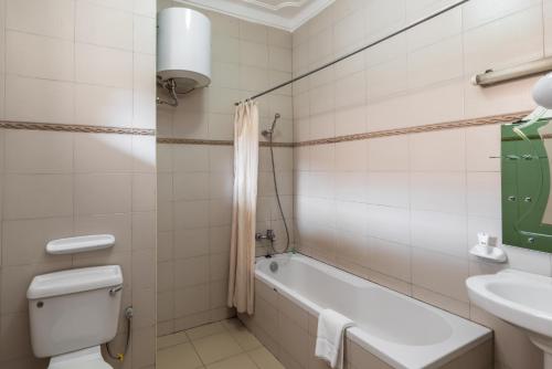 La salle de bains est pourvue d'une baignoire, de toilettes et d'un lavabo. dans l'établissement Entebbe Traveller's Hotel, à Entebbe
