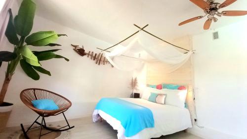 - une chambre avec un lit et un ventilateur de plafond dans l'établissement A LA KAZ TI ZOZEFF, à Saint-Joseph