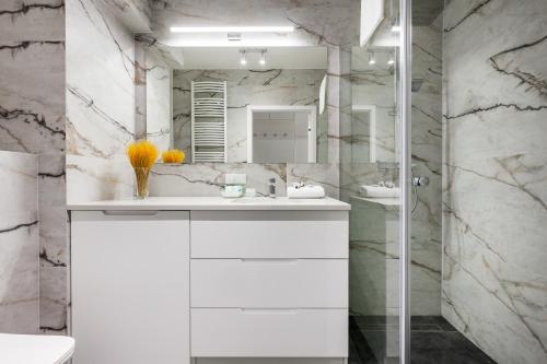 a bathroom with a white sink and a shower at Happy Stay Chlebova Residence in Gdańsk