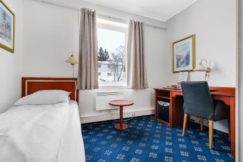 Schlafzimmer mit einem Bett, einem Schreibtisch und einem Stuhl in der Unterkunft Finnsnes Hotel in Finnsnes